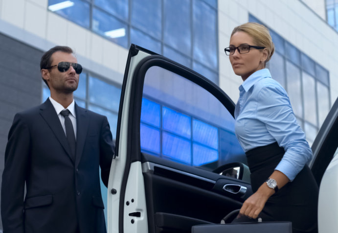 bodyguard escorting lady out of vehicle